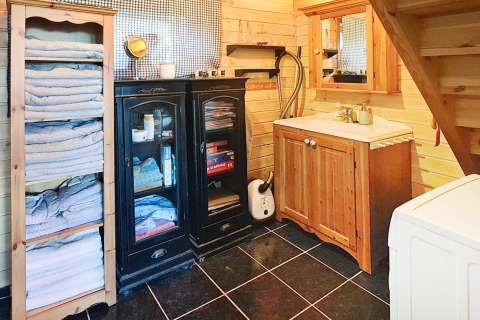 Badezimmer im Holzstil mit Handtuchregalen, Schränken, Waschbecken und Spiegel im Ferienhaus in Tau.
