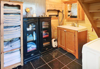 Badkamer met houten interieur, handdoekenrek, kasten, wastafel en spiegel in vakantiehuis in Tau.