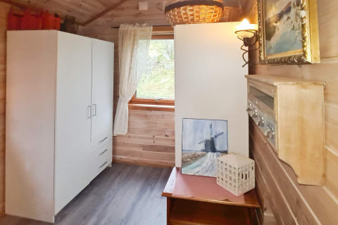 Lichte kamer in een vakantiehuis in Tau, Denemarken, met een witte kast en kunstwerken.