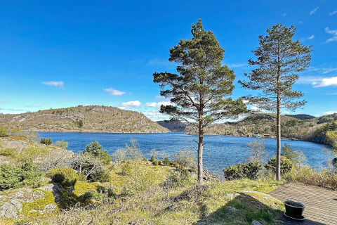 Smuk udsigt over søen og bakkerne fra HUS 55762 HYTTE A i Danmark med klart blå himmel.
