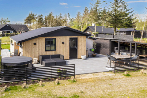 Maison de vacances 4 étoiles moderne à Løgstør, terrasse extérieure, jacuzzi et cadre verdoyant.