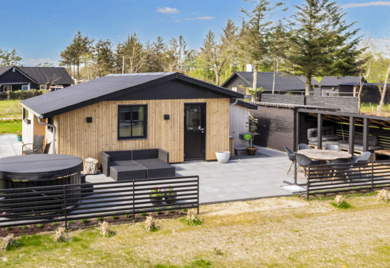 Moderne 4-stjernet feriehus i Løgstør med udendørs terrasse, jacuzzi og elegant haveområde.