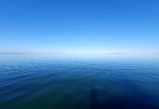 Vue sur la mer calme sous un ciel bleu clair au gîte 6 personnes à Bogense, au Danemark.