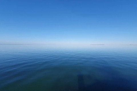 Vista del mar tranquilo bajo un cielo azul claro en la casa de vacaciones para 6 personas en Bogense, Dinamarca.
