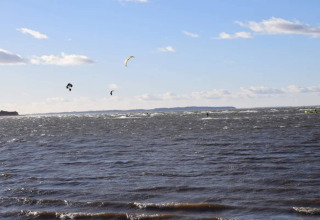 Kitesurfistas en el agua vistos desde una casa de vacaciones para 6 personas en Bogense, Dinamarca.
