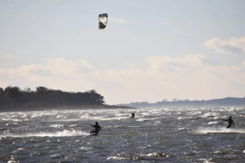 Kitesurfers genieten van de golven vlakbij het 6-persoons vakantiehuis in Bogense, Denemarken.