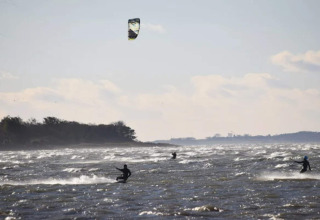Kitesurfere nyder bølgerne ved kysten ved ferieboligen 6 personers feriehus i Bogense, Danmark.