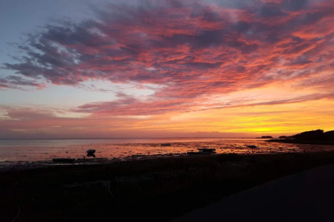 Sonnenuntergang am Meer vom 6-Personen-Ferienhaus in Bogense, Dänemark, mit leuchtenden Wolken.