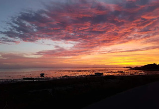Prachtige zonsondergang aan de kust vanaf het 6-persoons vakantiehuis in Bogense, Denemarken, met kleurrijke wolken.