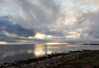 Sonnenuntergang am Meer mit dramatischem Himmel, gesehen vom 6-Personen-Ferienhaus in Bogense, Dänemark.