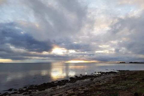 Sonnenuntergang am Meer mit dramatischem Himmel, gesehen vom 6-Personen-Ferienhaus in Bogense, Dänemark.