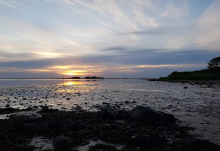 Zonsondergang bij de ondiepe kust vlakbij het 6 persoons vakantiehuis in Bogense, Denemarken.