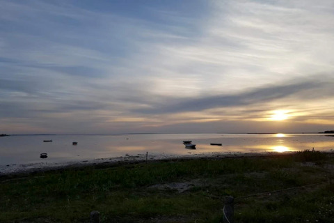 Coucher de soleil sur un lac paisible avec bateaux, vu depuis un gîte pour 6 personnes à Bogense.