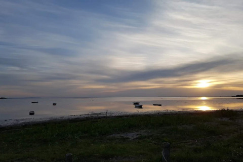 Zonsondergang over rustige waterplas met bootjes, vanuit 6-persoons vakantiehuis in Bogense, Denemarken.
