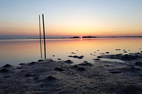 Coucher du soleil sur un paysage côtier à faible profondeur près d'une maison de vacances à Bogense, Danemark.