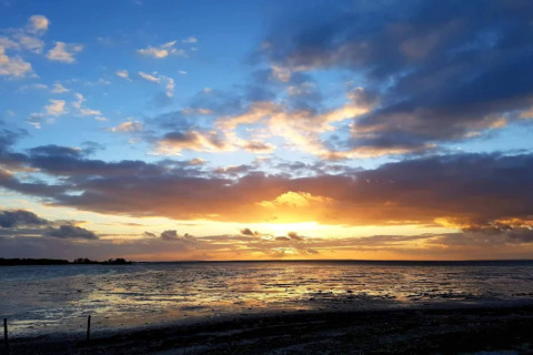 Prachtige zonsondergang aan zee gezien vanuit het 6-persoons vakantiehuis in Bogense, Denemarken, met lichte wolken.