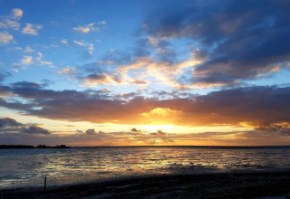 Hermosa puesta de sol sobre el mar desde la casa vacacional para 6 personas en Bogense, Dinamarca, con nubes coloridas.
