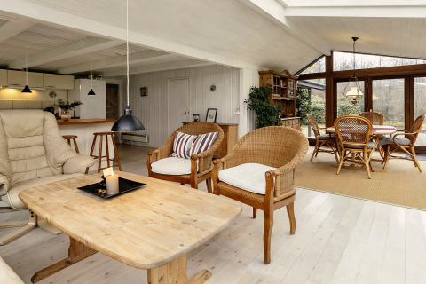 Espace salon lumineux et spacieux dans une maison de vacances à Bogense, Danemark, avec de grandes fenêtres.