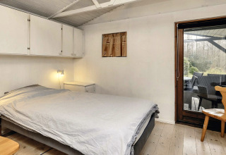 Slaapkamer in een 6-persoons vakantiewoning in Bogense, Denemarken, met tweepersoonsbed en terrasdeur.