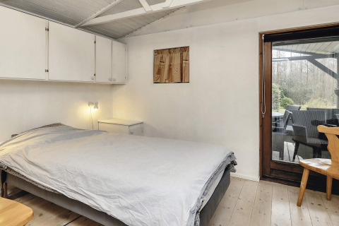 Dormitorio en casa vacacional para 6 personas en Bogense, Dinamarca, con cama doble y acceso a la terraza.