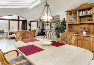 Woon- en eetruimte in 6-persoons vakantiehuis in Bogense, Denemarken, met houten meubels en grote ramen.