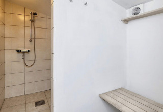 Douchehoek met bankje en ventilatie in een 6-persoons vakantiehuis in Bogense, Denemarken.