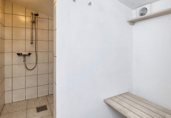 Shower area with bench and ventilation fan in a 6-person holiday home in Bogense, Denmark.