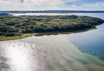 Luftaufnahme einer grünen Halbinsel am Wasser bei der 4 star holiday home in Rønde, Dänemark.