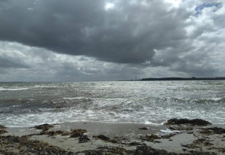 Blick auf das Meer und den Strand unter dramatischen Wolken, aufgenommen in Rønde, Dänemark.