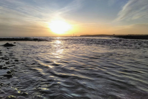 Sunset view from the coast at 4 star holiday home in Rønde, Denmark, with calm sea and scenic sky.