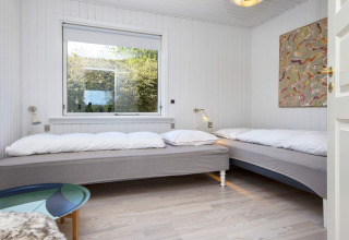 Schlafzimmer mit zwei Einzelbetten, großem Fenster, Wandlampen und moderner Kunst in Rønde, Dänemark.