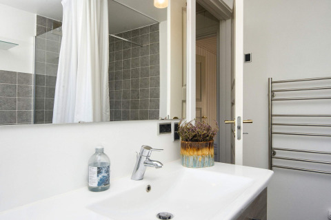 Moderne badkamer in 4-sterren vakantiewoning in Rønde met wastafel, spiegel en handdoekradiator.