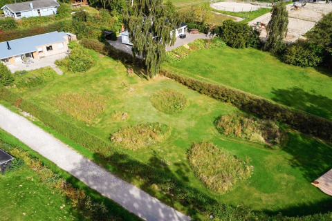 Aerial view of the 4 star holiday home in Rønde, Denmark, showing garden areas, lawn, and paddocks.
