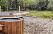 Vasca idromassaggio in legno e campo da pallavolo vicino alla natura in casa 5 stelle a Øster Assels, Danimarca.