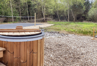 Vasca idromassaggio in legno e campo da pallavolo vicino alla natura in casa 5 stelle a Øster Assels, Danimarca.