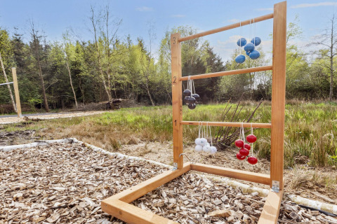 Buiten laddergolfspel met gekleurde ballen aan een houten frame bij een lodge in Øster Assels, Denemarken.