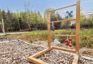 Gioco di ladder golf all'aperto con palle colorate su una struttura in legno vicino a una casa vacanza.