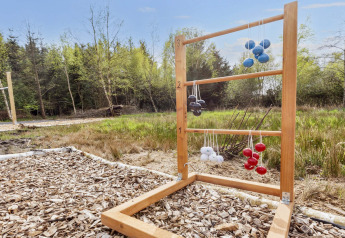 Laddergolfspel buiten met gekleurde ballen aan een houten frame bij een vakantiehuisje in Denemarken.