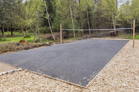 Udendørs badmintonbane med asfaltbelægning omgivet af skov ved 5-stjernet feriehus i Øster Assels, Danmark.