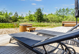 Udendørs terrasse med liggestole, vildmarksbad og træbænk ved 5-stjernet feriehus i Øster Assels, Danmark