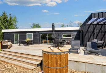 Udsigt over terrasse og udendørsområde ved 5-stjernet feriehus i Øster Assels, Danmark, med havemøbler.