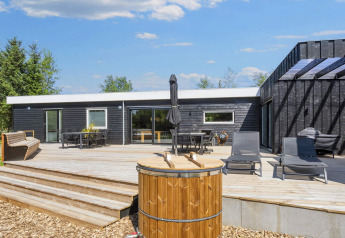 Terrasse und Außenbereich des 5-Sterne-Ferienhauses in Øster Assels, Dänemark, mit modernen Möbeln.