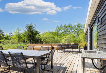Amplia terraza en una casa de vacaciones de 5 estrellas en Øster Assels, Dinamarca, con zona de comedor exterior.