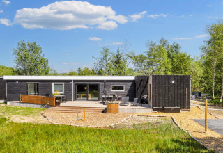 Modernes Ferienhaus in Øster Assels, Dänemark, mit großer Terrasse und umgeben von grüner Natur.