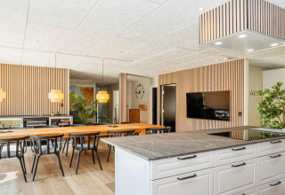 Cucina e sala da pranzo moderne in una casa vacanze a 5 stelle a Øster Assels, Danimarca, con dettagli in legno.