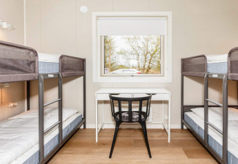 Habitación moderna en casa vacacional de 5 estrellas en Øster Assels, Dinamarca, con literas y escritorio.