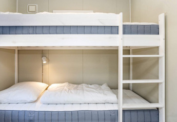Camera con letti a castello e arredamento minimalista nella casa vacanze 5 stelle a Øster Assels, Danimarca.
