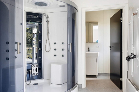 Bagno moderno con cabina doccia di lusso e lavandino bianco in una casa vacanze a Øster Assels, Danimarca.