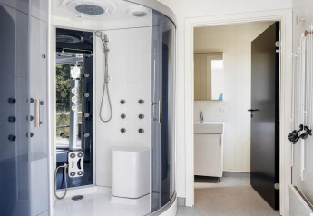 Modern bathroom with luxury shower cabin and white sink in a holiday home in Øster Assels, Denmark.