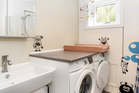 Waskamer in 5-sterren vakantiehuis in Øster Assels, Denemarken, met wasmachines en grappige monsterstickers.